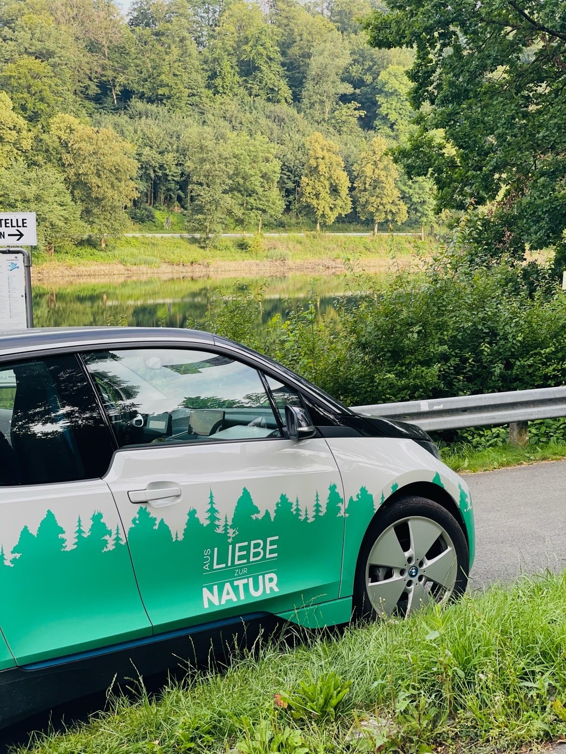 [Translate to Französisch:] grünes Auto mit Schriftzug "Aus Liebe zur Natur"ur"